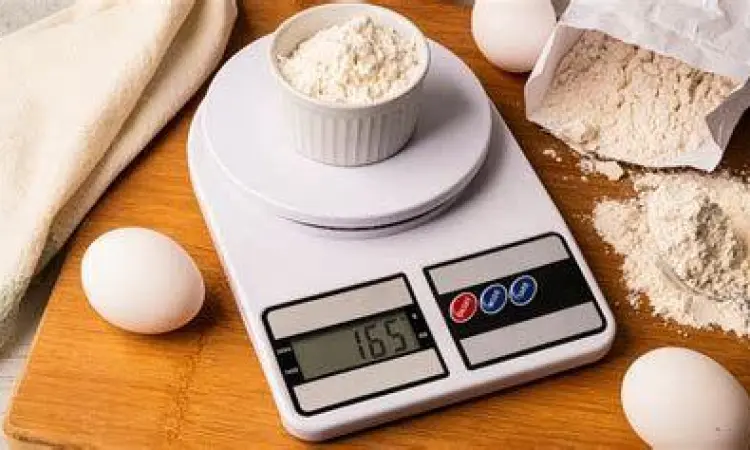 Koki profesional menggunakan timbangan digital untuk presisi bahan