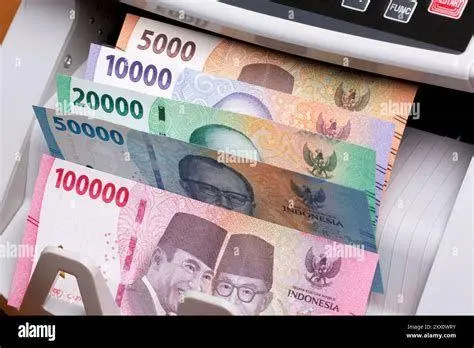 Ilustrasi Uang Rupiah Menghitung tumpukan uang rupiah untuk memahami 1 m berapa juta