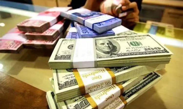 Perbandingan tumpukan uang rupiah dan dolar AS di atas meja