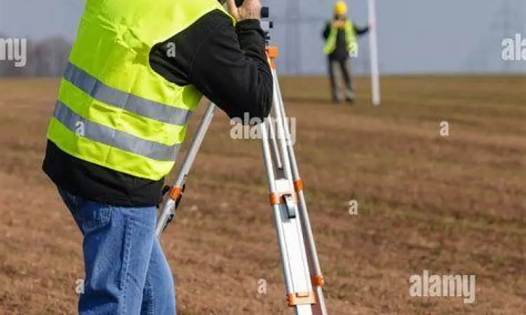 Petugas mengukur lahan menggunakan alat survey profesional